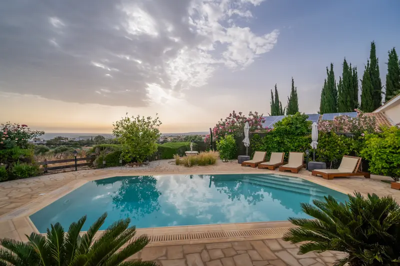 Overflow pool with textured sand-colored liner blends perfectly with the garden. Steps for easy access. Solar-heated outdoor shower for rinsing off. Pool heating is available during the cooler months for an added fee, ensuring year-round comfort.