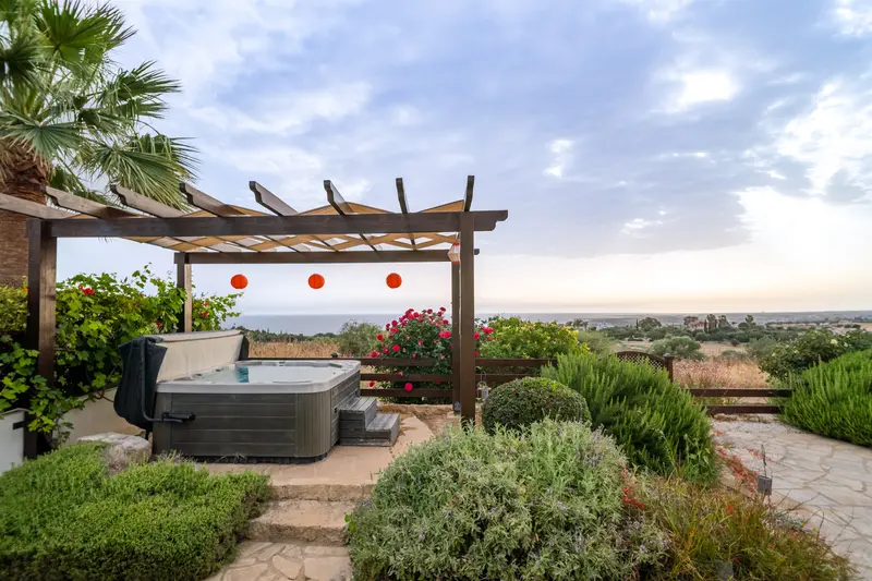 The outdoor hot tub for six people sits on an elevated platform that gives you stunning views out over the sea and the hills around Paphos.
