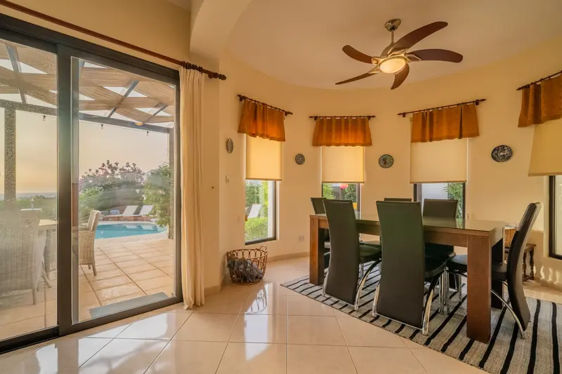 The dining area sits in its own round room with windows all around, but is directly connected to the living room and kitchen. High chair available on request.