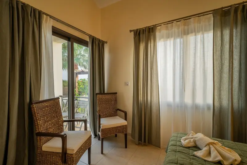 Green bedroom with private patio, king size bed, ceiling fan, dedicated AC/heating unit, vanity, large built-in wardrobes, bluetooth speaker/alarm clock. Views of the sea and the roses and hibiscus in the garden. Ensuite bathroom with walk-in shower.