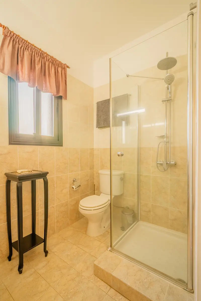 Full bathroom in hallway with walk-in shower and heated towel rails.
