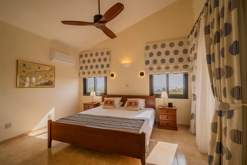 Master king ensuite bedroom with sea views and terrace access. King size bed, ceiling fan, dedicated AC/heating unit, vanity, large built-in wardrobes, bluetooth speaker/alarm clock.