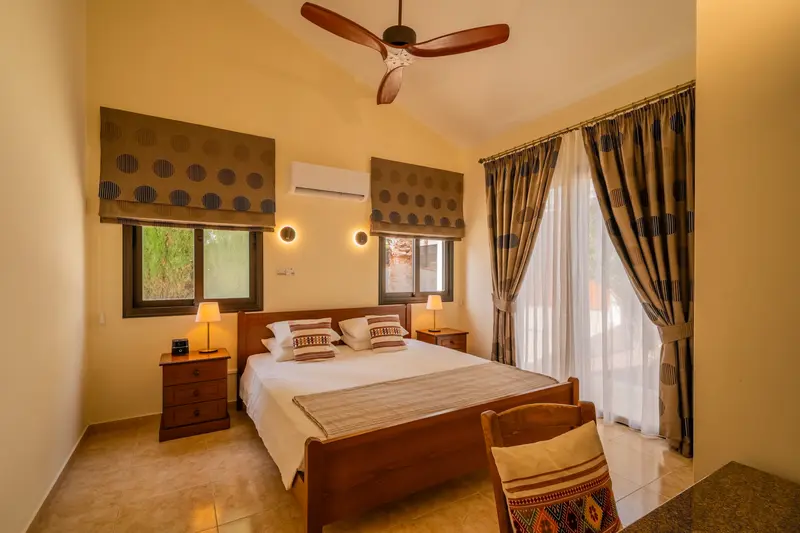 First king bedroom with direct patio access. King size bed, ceiling fan, dedicated AC/heating unit, vanity, large built-in wardrobes, bluetooth speaker/alarm clock.