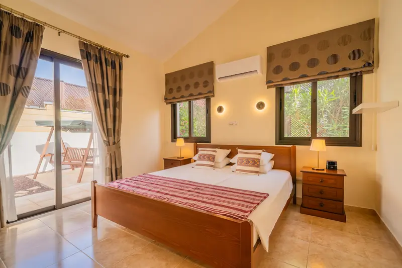 Second king bedroom with direct patio access. King size bed, ceiling fan, dedicated AC/heating unit, vanity, large built-in wardrobes, bluetooth speaker/alarm clock.